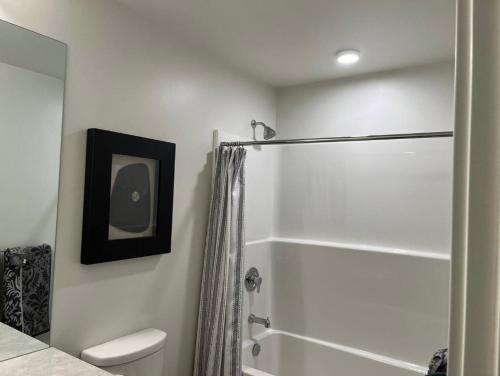 a white bathroom with a shower and a toilet at Brand New 3-Bedroom Condo in the Heart of Sidney in Sidney