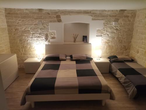 - une chambre avec 2 lits dans une pièce aux murs en pierre dans l'établissement B&b il castello, à Giovinazzo