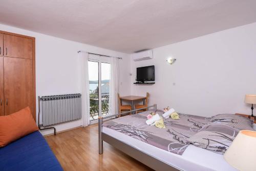 un dormitorio con una cama con dos animales de peluche en Lulak Studio Apartments, en Orebić