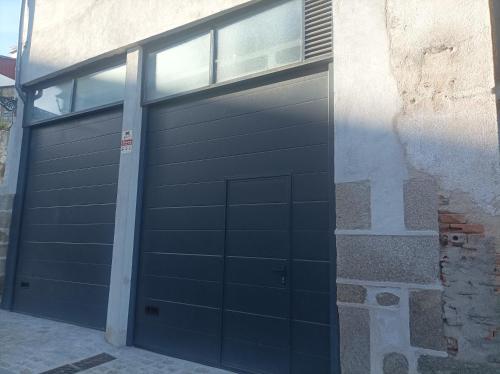una puerta de garaje con una ventana en el lateral de un edificio en Bejar Alojamiento La Plaza, en Béjar