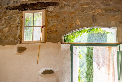 a window in a stone building with a stick at Agriturismo Nonnamelia in Nasino