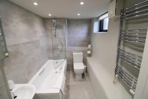 a bathroom with a toilet and a shower and a sink at Brae Fell Cottage, Sebergham, Nr Caldbeck in Sebergham