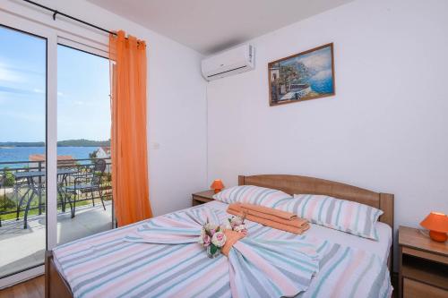 a bedroom with a bed with a view of the ocean at Lulak Studio Apartments in Orebić