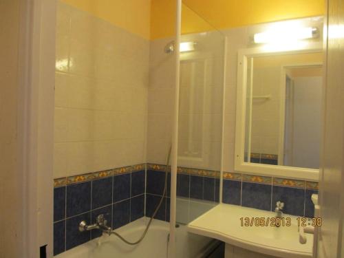 een badkamer met een bad, een wastafel en een spiegel bij Appartement à louer village P et V Domaine du Golf de Pont Royal en Provence in Mallemort