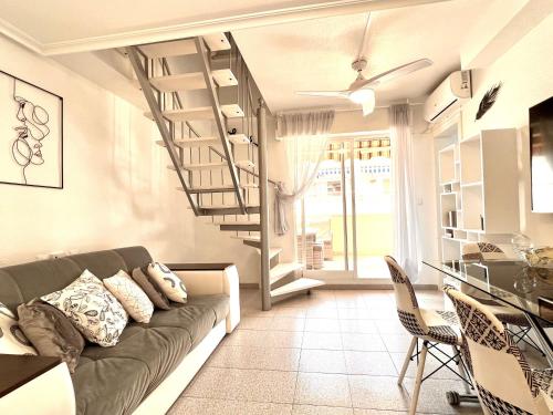 ein Wohnzimmer mit einem Sofa und einer Wendeltreppe in der Unterkunft Holiday Penthouse Jardin in Torrevieja