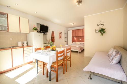 eine Küche und ein Wohnzimmer mit einem Tisch und Stühlen in der Unterkunft Apartmani Rita in Baška Voda