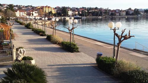 a row of lights on a sidewalk next to the water at Apartments Adriatic in Selce