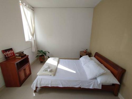 ein Schlafzimmer mit einem großen Bett und einem Fenster in der Unterkunft Luminoso hospedaje con balcón in Cali