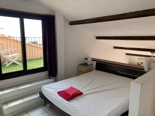 une chambre avec un lit avec un oreiller rouge dessus dans l'établissement Appart vue mer panoramique magique, à Saint-Mandrier-sur-Mer