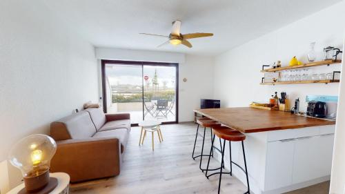 une cuisine et un salon avec un canapé et une table dans l'établissement Terrasse de la Tour du Port, à Saint-Gilles-Croix-de-Vie