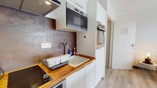 une cuisine avec un évier et un plan de travail dans l'établissement Terrasse de la Tour du Port, à Saint-Gilles-Croix-de-Vie