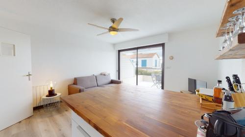 un salon avec un canapé et un ventilateur de plafond dans l'établissement Terrasse de la Tour du Port, à Saint-Gilles-Croix-de-Vie