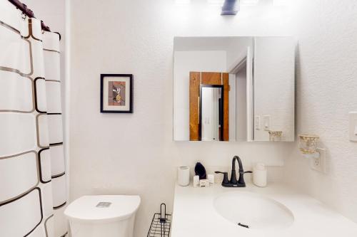 Baño blanco con lavabo y espejo en Desert Treasure, en Phoenix