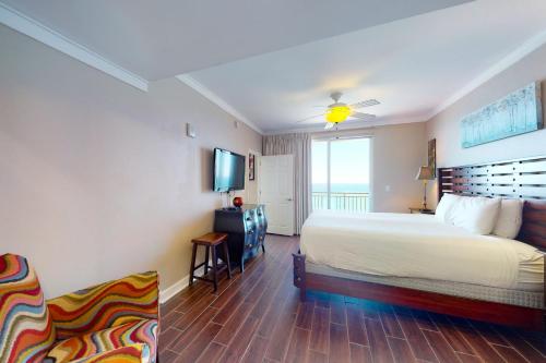 パナマ・シティ・ビーチにあるSplash Beach Resort 1206Wのベッドとテレビが備わるホテルルームです。