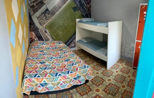 a bedroom with a bed and a bunk room with a bed gmaxwell gmaxwell at Rolds Hostel in Santos