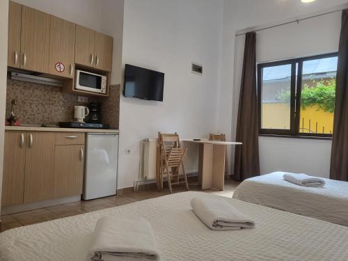 una camera con due letti e una cucina con finestra di Casa Rezidentiala Aria a Cluj-Napoca