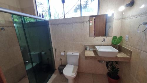 a bathroom with a toilet and a sink and a shower at Chalé da Serra in Cavalcante