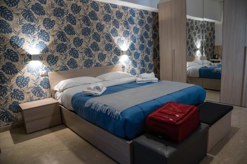 Un dormitorio con una cama con una maleta roja. en Dolce Vita en Messina