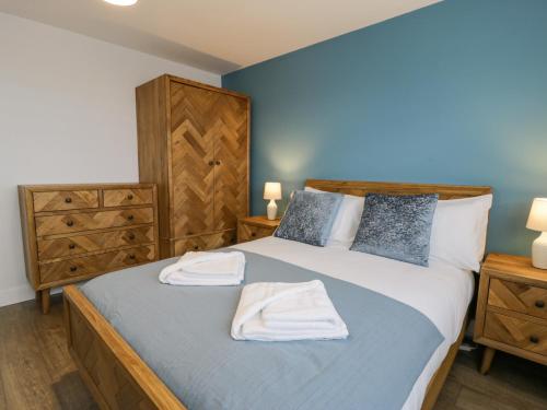 a bedroom with a bed with two towels on it at Melody in Cemaes Bay