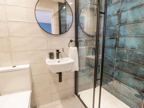 a bathroom with a shower and a sink and a mirror at Melody in Cemaes Bay