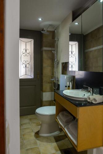 a bathroom with a sink and a toilet and a mirror at Vaggelis House in Megáli Vrísi