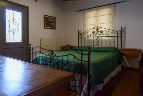 a bedroom with a bed with a green comforter at Vaggelis House in Megáli Vrísi