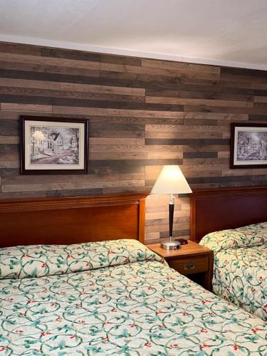 a hotel room with two beds and a lamp at Doray Motel Lake George in Lake George