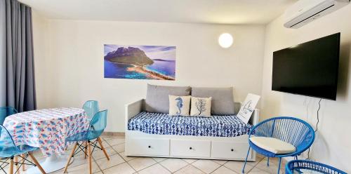 オルビアにあるLa casa al mare, Pittulonguのベッド、テーブル、椅子が備わる客室です。