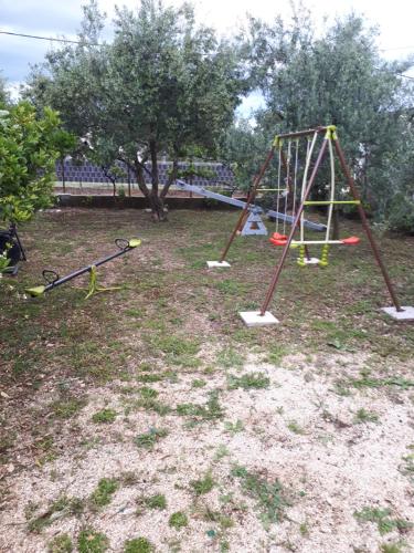 a playground with a swing set in a park at Apartman Laura in Kaštela