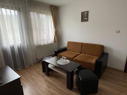 a living room with a couch and a table at Къща за гости Александра in Dobrinishte
