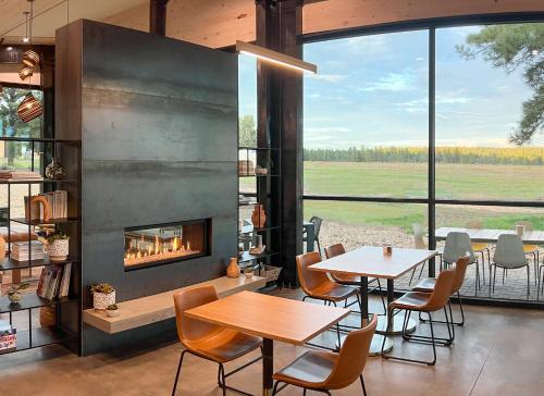 a dining room with tables and a fireplace at Backland in Williams