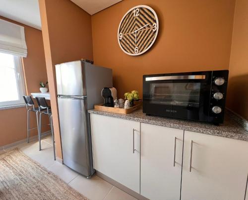 a kitchen with a microwave and a refrigerator at Douro Valley Terrace Apartments in Armamar