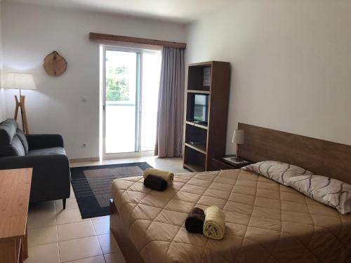 Un dormitorio con una cama grande y una sala de estar en AZORES GARDEN HOUSE - Private Suites & Apartments - Automatic Self Check-in, en Ponta Delgada
