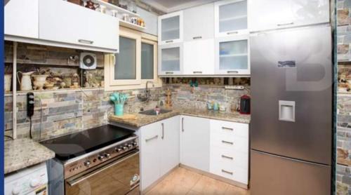a kitchen with white cabinets and a stainless steel refrigerator at Gleem Bay View in Alexandria
