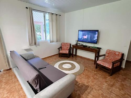 a living room with a couch and a tv at FARE ARIKI MOOREA in Afareaitu