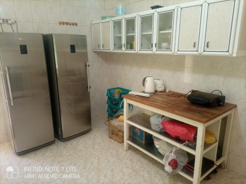 cocina con nevera de acero inoxidable y mesa en Decapolis, en Irbid