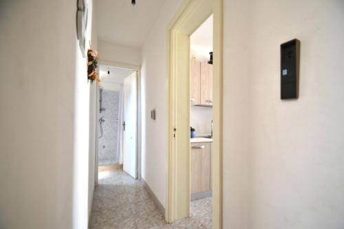 einen Flur mit einer Tür, die zu einer Küche führt in der Unterkunft Pt57 Casa vacanza per 4 pax Alba in Torre dell'Orso