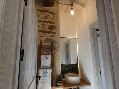 Cortes de ArenosoにあるLa Esencia Casa Ruralのバスルーム(鏡、タオル付きの棚付)