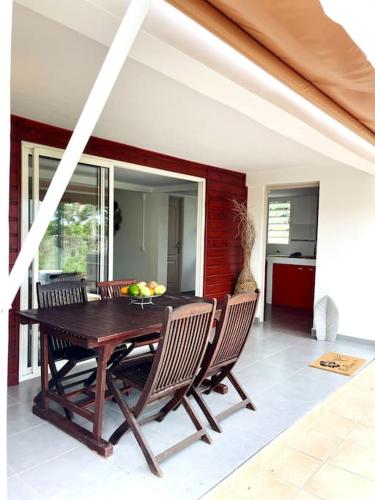 comedor con mesa de madera y sillas en Villa le Cotonnier Lodge, en Saint-François