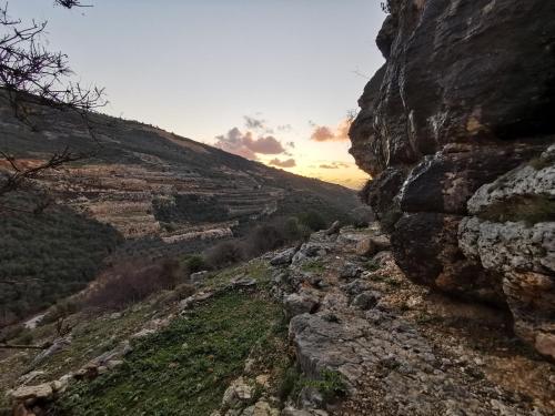 a view of a rocky mountain with the sunset in the background at סוויטה בכפר ירכא in Yarka
