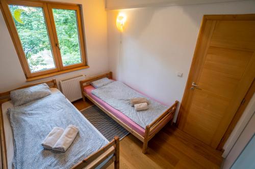 um pequeno quarto com 2 camas e uma janela em Tri pera -- self check in em Osijek