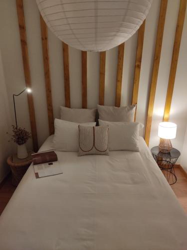 a bedroom with a large white bed with striped walls at Douro Valley Terrace Apartments in Armamar