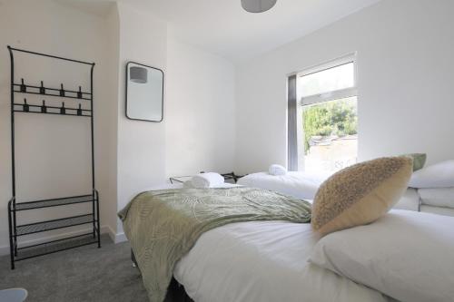 a white bedroom with two beds and a window at StayRight 2 Bedroom House in Pontypool near Canals- Freshly renovated in Griffithstown