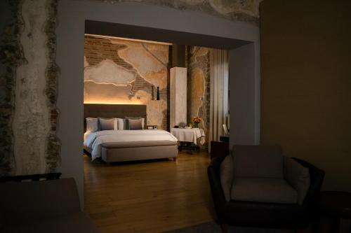 a bedroom with a bed and a couch and a chair at Cartesiano Boutique & Wellness Hotel in Puebla