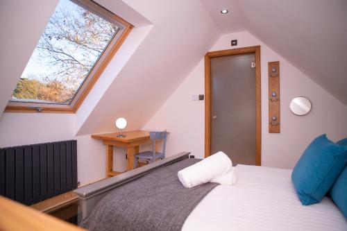 een slaapkamer op zolder met een bed en een raam bij Luxury Barn House - Central Oxford/Cotswolds in Cassington