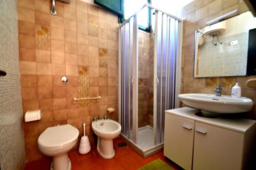 ein Badezimmer mit Toilette, Waschbecken und Dusche in der Unterkunft Pt56 Villetta per 6 pax Aria in Torre dell'Orso