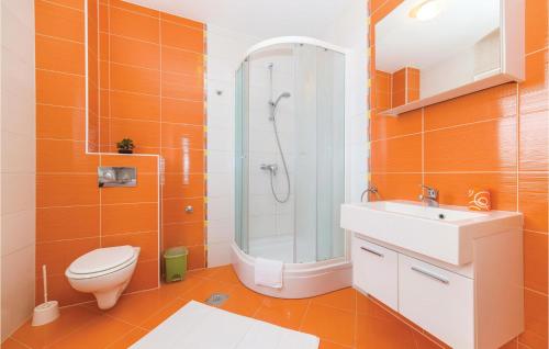 y baño de color naranja con aseo y ducha. en Amazing Apartment In Okrug Gornji With Kitchen, en Trogir