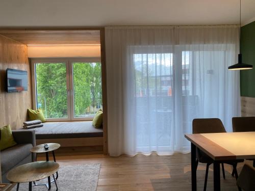 a living room with a bed and a large window at Livero Apartments in Sankt Pölten