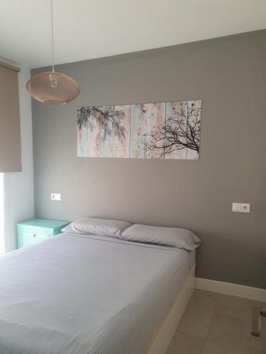 a bedroom with a bed and a painting on the wall at Casa Azul de la Almedina de Almería in Almería