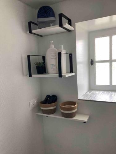 une salle de bain avec des étagères au mur avec une fenêtre dans l'établissement Gîte des 4 vents, proche du lac de Guerlédan, à Saint-Aignan